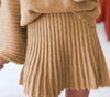 Close-up of a person wearing a brown ribbed sweater and skirt.